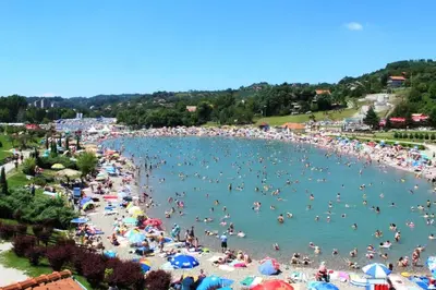 a crowd of people in the water at a beach at A First class za 4 osobe 2 spavaće sobe in Tuzla