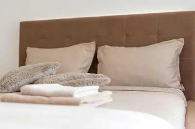 a bed with pillows and towels on top of it at Drobac apartman in Banja Luka