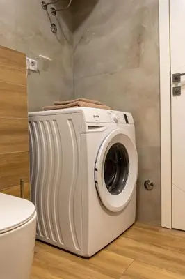 a washing machine in a bathroom next to a toilet at Drobac apartman in Banja Luka