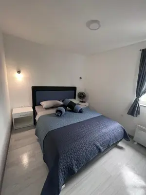 a bedroom with a large bed with a blue blanket at Amani in Kovačevo Polje