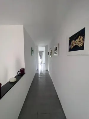 a hallway with white walls and pictures on the walls at Amani in Kovačevo Polje