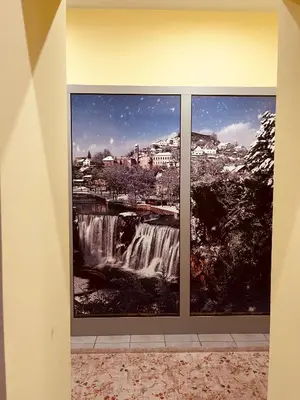 a room with two pictures of a waterfall at Apartman Vinkov's center in Jajce