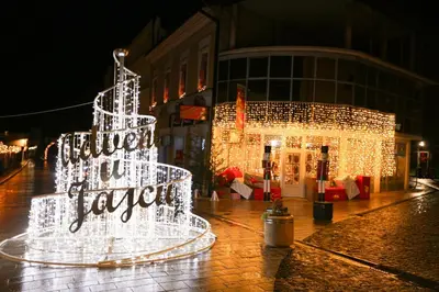 a christmas tree in front of a building with lights at Apartman Vinkov's center in Jajce