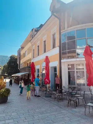 a group of people standing outside a building with red umbrellas at Apartman Vinkov's center in Jajce