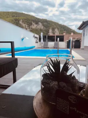a plant in a glass bowl on a table near a pool at Apartman Kiss in Jajce
