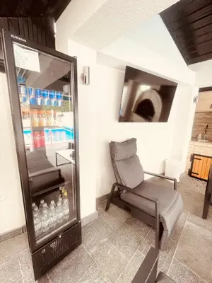 a room with a chair and a glass refrigerator at Apartman Kiss in Jajce