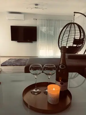 a bottle of wine and two glasses on a table at Apartman Kiss in Jajce