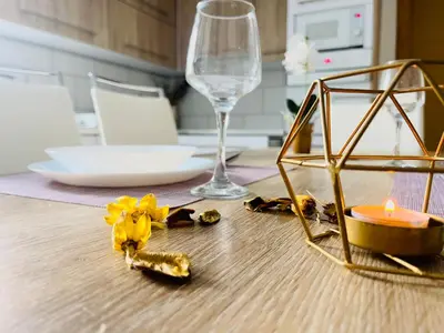 a dining table with a candle and a wine glass at Apartman Kiss in Jajce