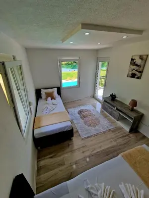 a room with two beds and a desk in it at Villa Eda in Bihać