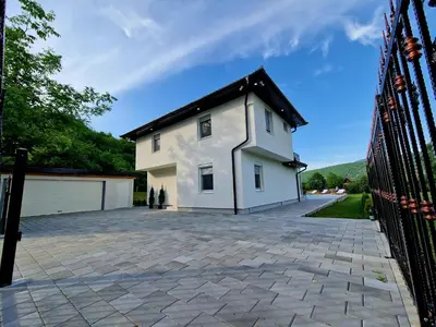a white house with a black roof and a driveway at Villa Eda in Bihać