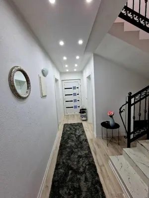 a hallway with a staircase and a mirror on the wall at Villa Eda in Bihać