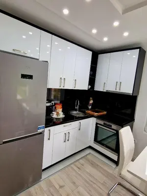 a kitchen with white cabinets and a stainless steel refrigerator at Villa Eda in Bihać