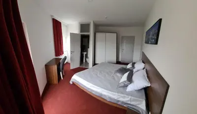 a bedroom with a bed with white sheets and pillows at Kašmir in Bugojno