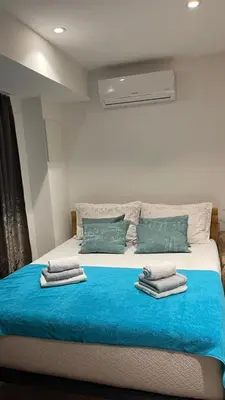 a bedroom with a large bed with blue sheets and pillows at Visoko New Concept - 7 minutes from the Pyramids - City Center in Visoko