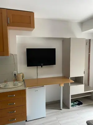 a kitchen with a desk with a tv on the wall at Visoko New Concept - 7 minutes from the Pyramids - City Center in Visoko
