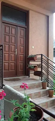 a front door of a house with flowers on the stairs at IKA-M in Bihać