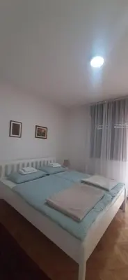a bedroom with a large bed with blue sheets at IKA-M in Bihać