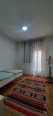 a room with a bed and a rug on the floor at IKA-M in Bihać