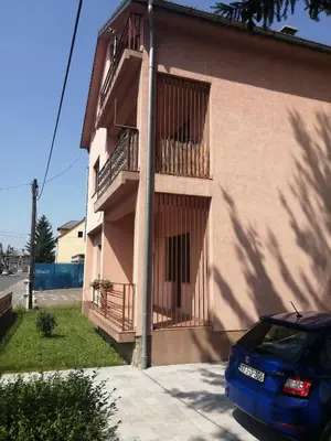 a blue car parked in front of a building at IKA-M in Bihać