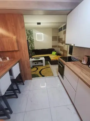 a kitchen and living room with a couch at Teslić Apartman NiA in Teslić