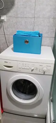 a blue box on top of a washing machine at Teslić Apartman NiA in Teslić