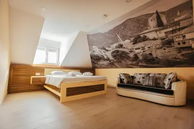 a bedroom with two beds and a painting on the wall at Grand villa Bosnae in Bihać