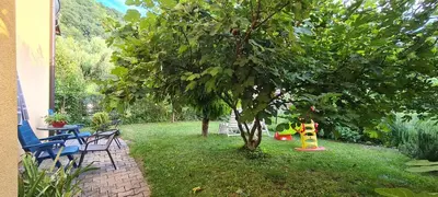 a yard with a tree and a table and chairs at Apartman Stari Grad - Ostrožac na Uni - Bihać Cazin in Ostrožac