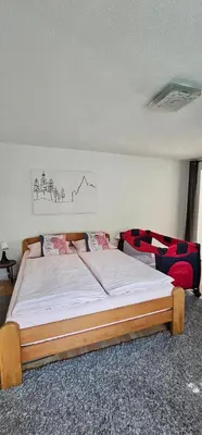a bedroom with a bed and two red chairs at Apartman Stari Grad - Ostrožac na Uni - Bihać Cazin in Ostrožac