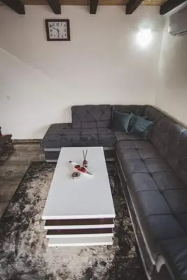 a living room with a couch and a white table at Villa Vanesa Bihać in Bihać