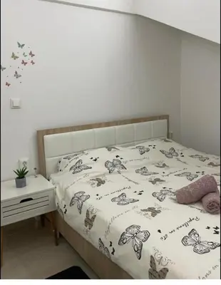 a bedroom with a bed with a butterfly blanket at Central13 App 2 in Tuzla