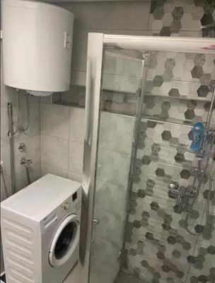 a washing machine in a bathroom with a shower at Central13 App 2 in Tuzla