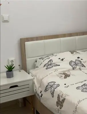 a bed with a white comforter with butterflies on it at Central13 App 2 in Tuzla