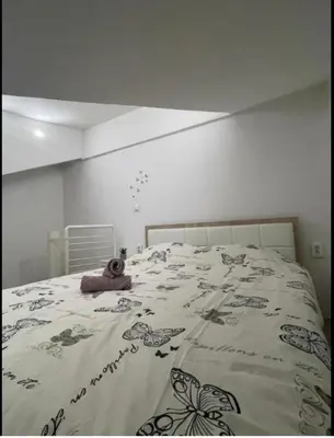 a teddy bear laying on a bed in a bedroom at Central13 App 2 in Tuzla