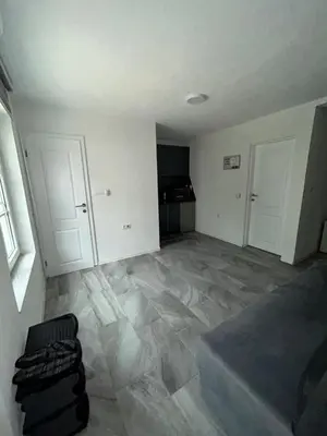 an empty living room with a couch and two white doors at Apartman Jasko 1 in Jajce