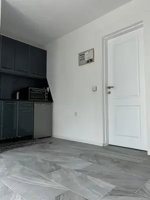 an empty room with a kitchen and a white door at Apartman Jasko 1 in Jajce
