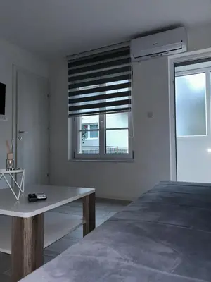 a bedroom with a bed and a window with blinds at Apartman Jasko 2 in Jajce