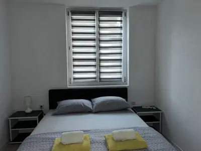 a bedroom with a bed with two pillows and a window at Apartman Jasko 2 in Jajce
