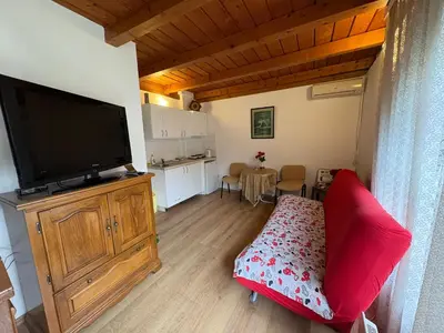 a living room with a flat screen tv and a red couch at Stan Centar in Banja Luka