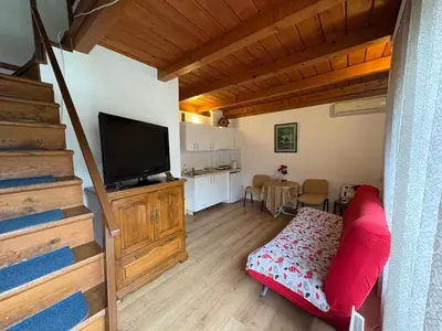 a living room with a flat screen tv and a staircase at Stan Centar in Banja Luka