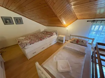 a bedroom with two beds and a wooden ceiling at Stan Centar in Banja Luka