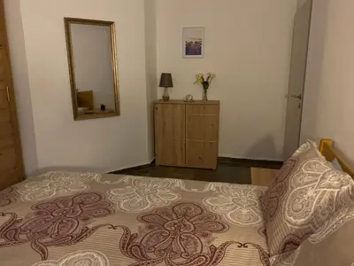 a bedroom with a bed with a mirror and a dresser at Apartment Pahuljica in Travnik