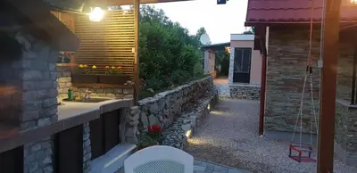 a bathroom with a sink and a stone wall at Green Garden Lohovo in Bihać
