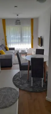 a living room with a table and chairs and a couch at apartman Kami in Tuzla
