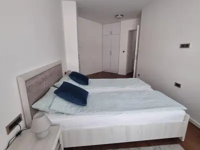 a bedroom with a large white bed with blue pillows at apartman Kami in Tuzla