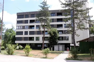 an apartment building with trees in front of it at apartman Kami in Tuzla
