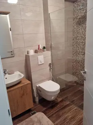 a bathroom with a toilet and a sink and a shower at apartman Kami in Tuzla