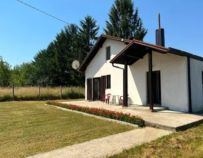 a small white building with flowers in front of it at Weekend house & apartments Dubrave in Visoko