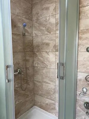 a bathroom with a shower with a glass door at Weekend house & apartments Dubrave in Visoko