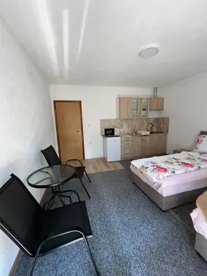 a bedroom with a bed and a table and chairs at Weekend house & apartments Dubrave in Visoko