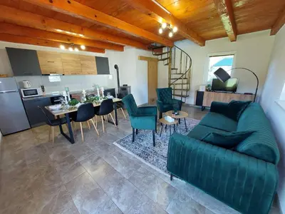 a living room with a couch and a table and a kitchen at La Reina Una in Bihać